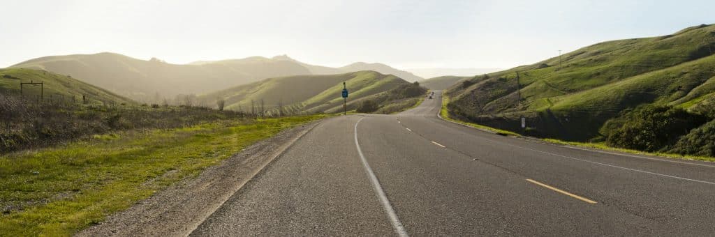 Weg in Cambria, Californië tussen groene heuvels