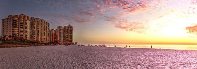 Zonsondergang op strand met gebouwen in Marco Island