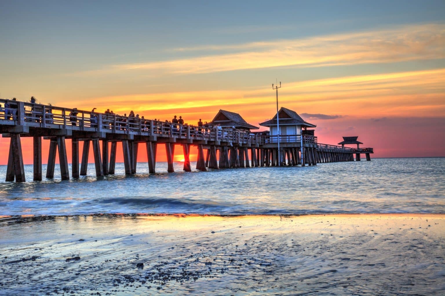 Pier met mensen bij zonsondergang in Naples, Florida