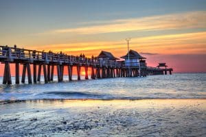 Pier met mensen bij zonsondergang in Naples, Florida