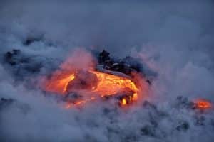 Lava stroomt door rotsen en stoom op Big Island, Hawaii