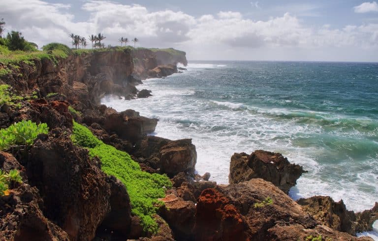Rotsachtige kustlijn in Poipu Hawaii met branding