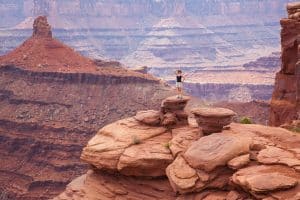 Vrouw op rotsformatie in Canyonlands, Utah