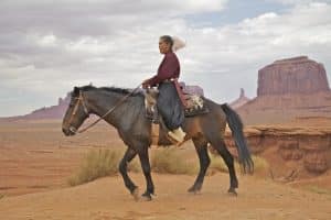 Navajo vrouw te paard in Monument Valley Arizona