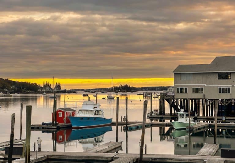 Haven van Boothbay Harbor bij zonsondergang met boten en houten pieren