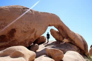 Archvormige rots met wandelaar in Joshua Tree National Park, California