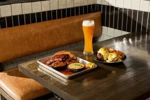 Kansas City barbecuegerechten en bier op tafel bij Meat Mitch