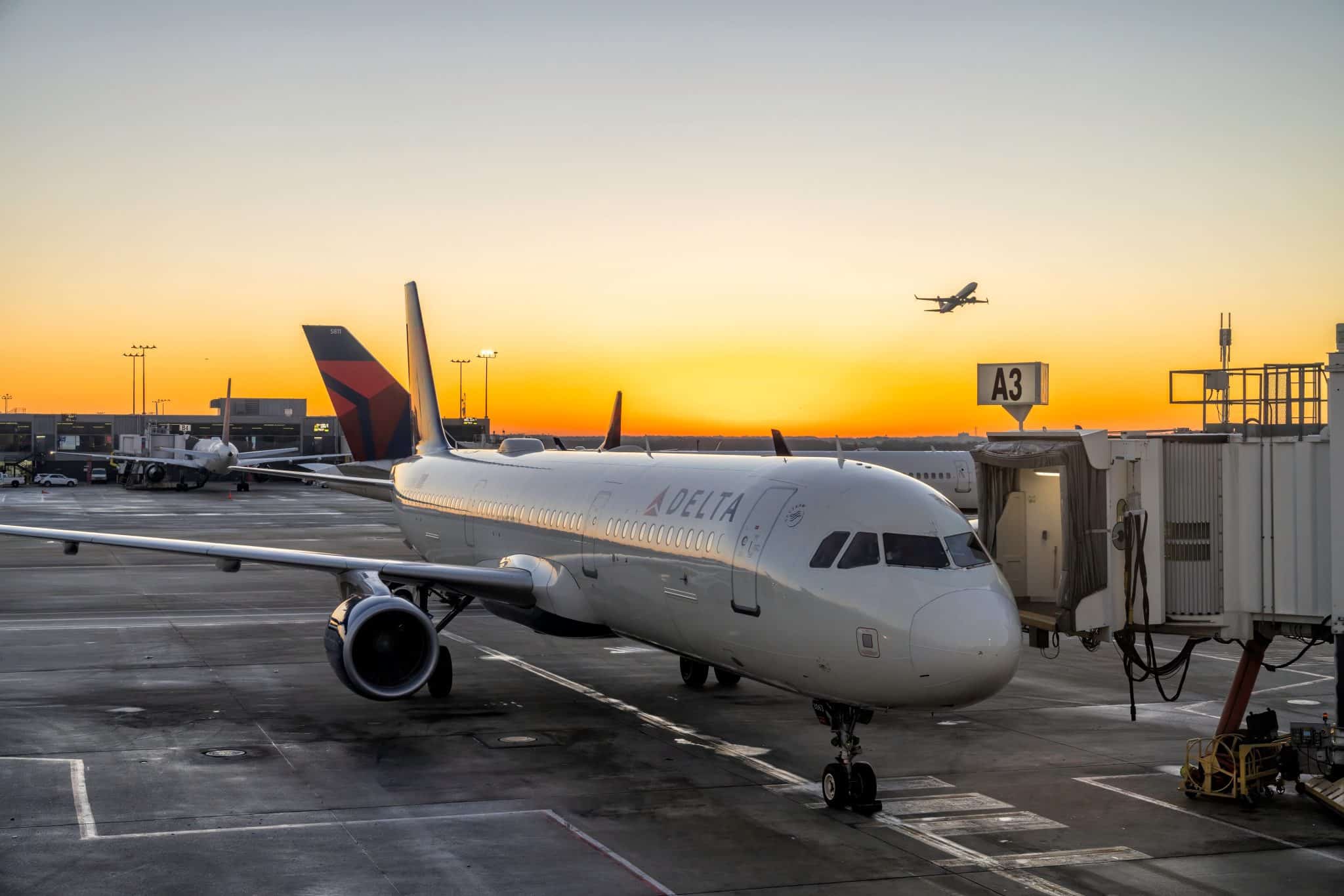 Delta Airlines vliegtuig bij gate tijdens zonsondergang