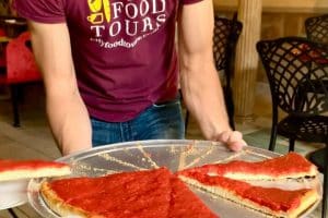 Man serveert pizza tijdens foodtour in Philadelphia