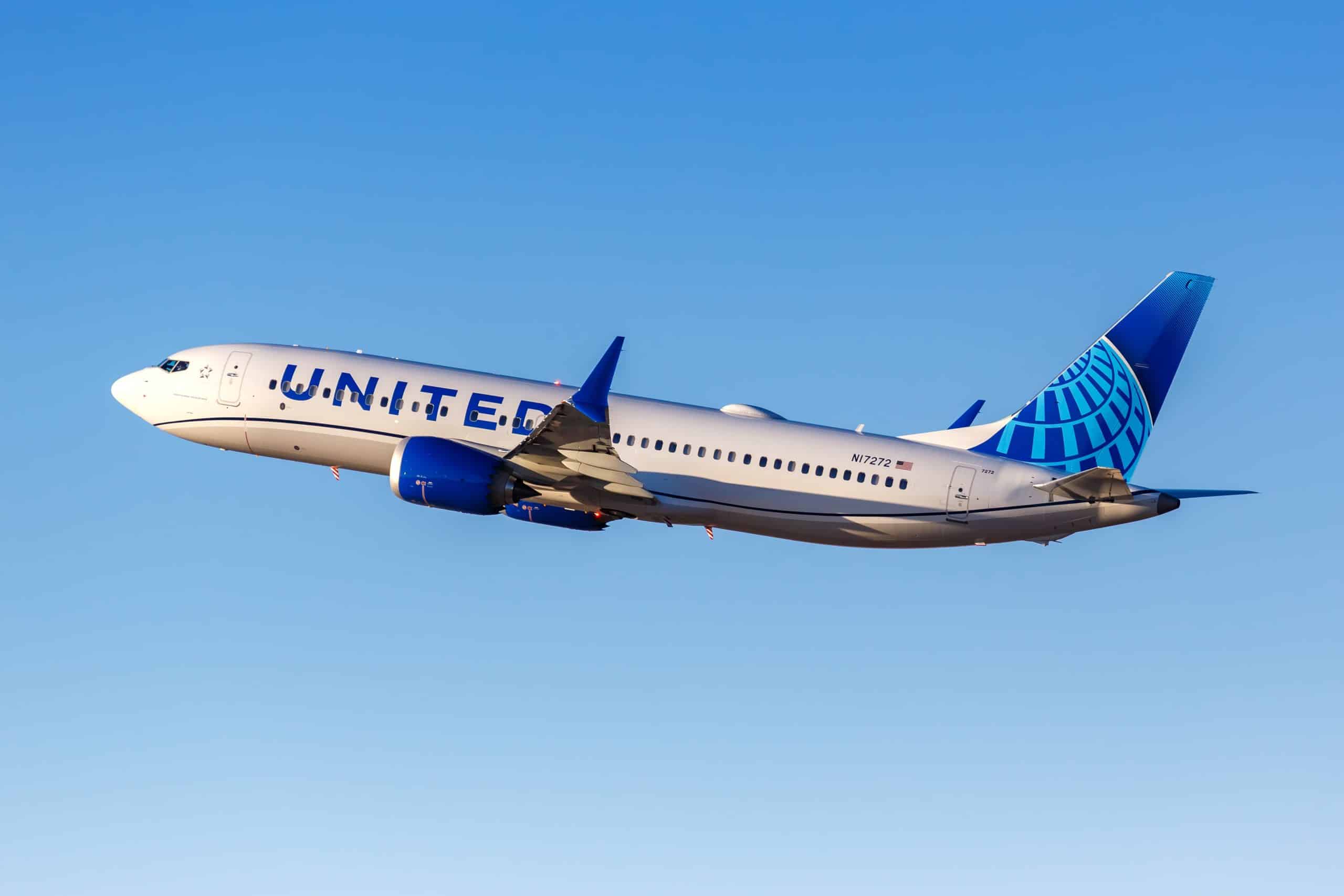 United Airlines vliegtuig in de lucht onder blauwe hemel