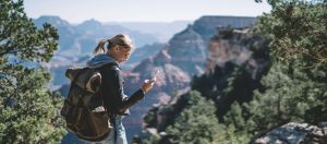 Wandelaar met telefoon, app en rugzak bij de Grand Canyon in Arizona