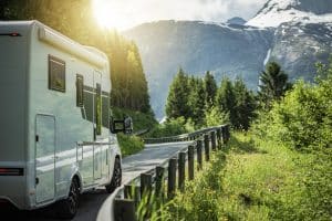 Camper op bergweg in natuur symbool voor zorgeloos reizen zonder eigen risico