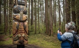 Bezoeker bij totempaal in het bos van Sitka