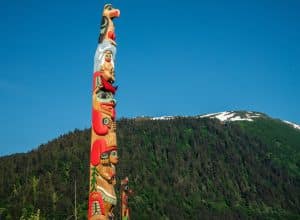 Totempaal in Sitka met bergen op de achtergrond