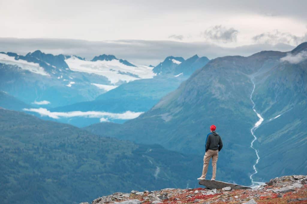 Persoon kijkt uit over bergen in Alaska