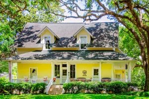 Historisch houten huis met veranda in Alabama tussen grote bomen