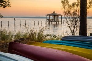 Gekleurde kajaks bij meer met steiger in Alabama