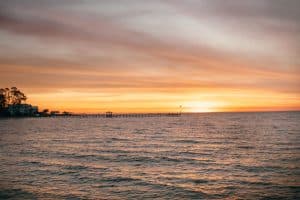 Zonsondergang over water met pier in Fairhope Alabama